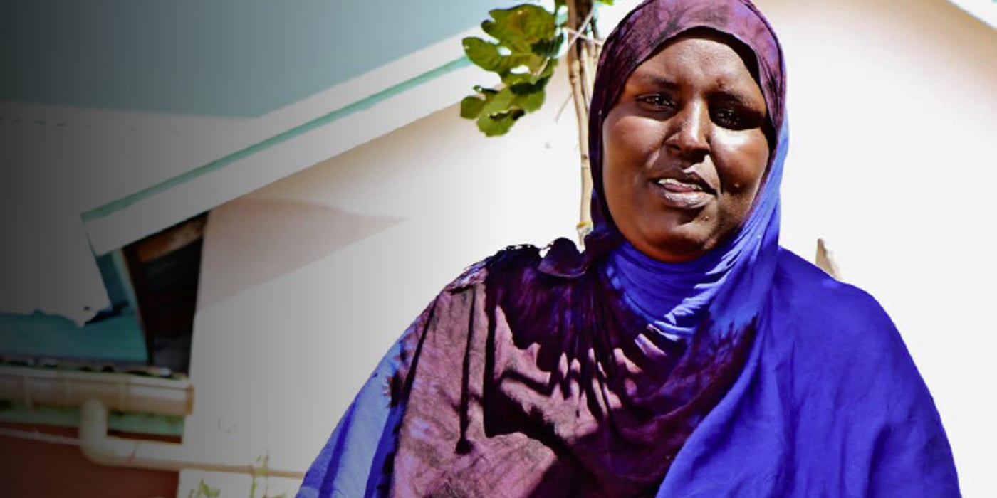 Front page of the "Amplifying the voices of Displacement Affected Communities" report. It shows a woman in a pink skirt and blue shawl smiling.
