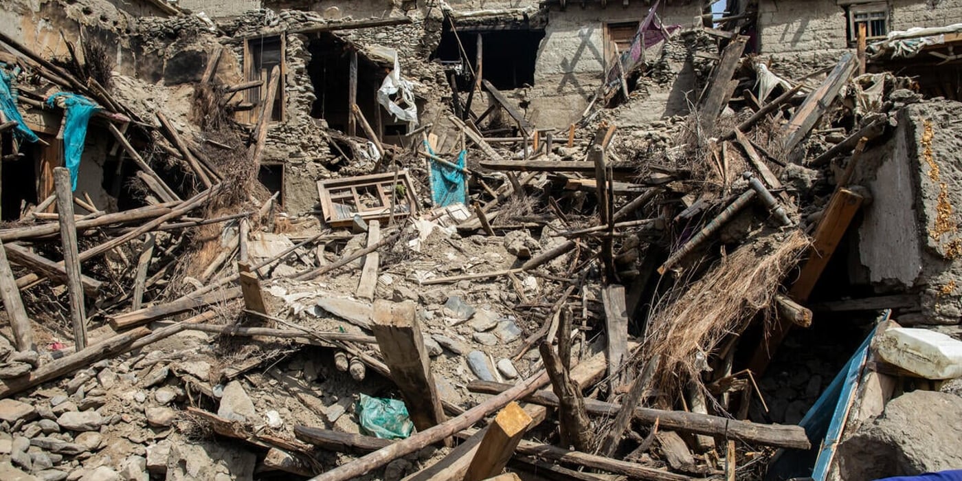 Bilden visar flera bostadshus som har rasat samman.  Delar av byggnaderna står fortfarande kvar, men är kraftigt skadade och instabila.