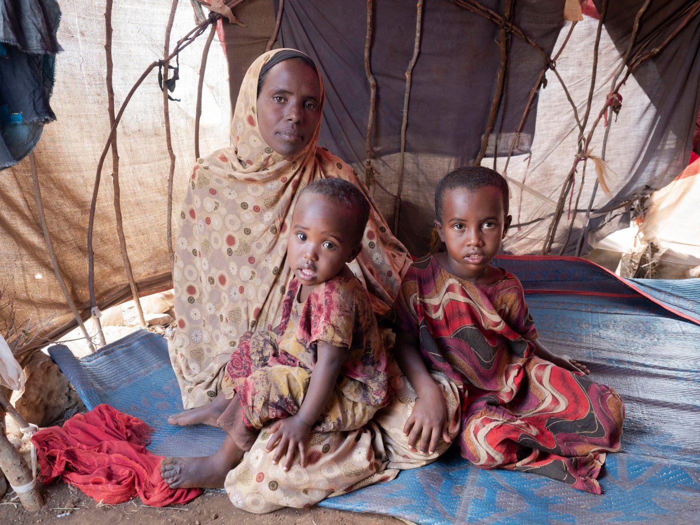 Faduma Abdinor Mohamed, 39, was pregnant with her youngest child when both her father and husband were killed during armed attacks. 

The compounding impact of drought left Faduma unable to feed and water her livestock, leaving her struggling to feed her children. When one of her sons became seriously ill, she sold her four surviving goats to pay for his medicine. She does not own any land but earned some money by working on other people’s farms. When the drought deteriorated, it was not possible to find any more work.

Eventually, the combined pressure of conflict and drought forced Faduma to move to Baidoa, an urban centre with greater access to humanitarian assistance.

“Children adapt to the place where they grow up and spend time.  I want my children to learn, to help their parents and build a future … and get an education that can give them opportunities everywhere. That is why I brought them here.”

With help from her brother, who lives in Mogadishu, Faduma is able to send her four oldest children to school, but she continues to struggling to provide enough for them enough to eat. 

“Last night we got something to eat from others. My children didn’t eat anything this morning. I had nothing to cook.”

Photo: Ingrid Prestetun/NRC