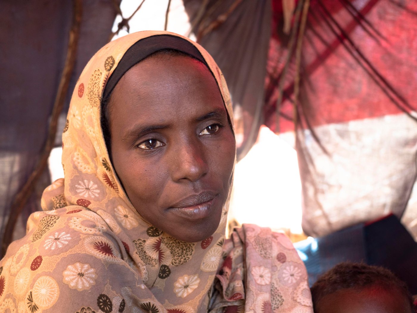 Faduma Abdinor Mohamed, 39, was pregnant with her youngest child when both her father and husband were killed during armed attacks. 

The compounding impact of drought left Faduma unable to feed and water her livestock, leaving her struggling to feed her children. When one of her sons became seriously ill, she sold her four surviving goats to pay for his medicine. She does not own any land but earned some money by working on other people’s farms. When the drought deteriorated, it was not possible to find any more work.

Eventually, the combined pressure of conflict and drought forced Faduma to move to Baidoa, an urban centre with greater access to humanitarian assistance.

“Children adapt to the place where they grow up and spend time.  I want my children to learn, to help their parents and build a future … and get an education that can give them opportunities everywhere. That is why I brought them here.”

With help from her brother, who lives in Mogadishu, Faduma is able to send her four oldest children to school, but she continues to struggling to provide enough for them enough to eat. 

“Last night we got something to eat from others. My children didn’t eat anything this morning. I had nothing to cook.”

Photo: Ingrid Prestetun/NRC