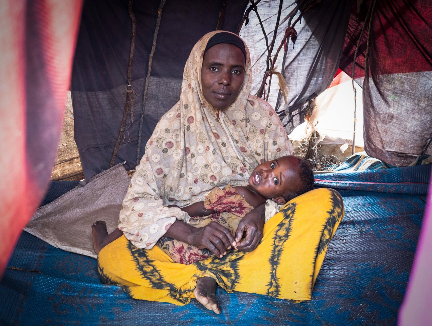 Faduma Abdinor Mohamed, 39, was pregnant with her youngest child when her husband was killed during armed attacks. The compounding impact of drought left Faduma unable to feed and water her livestock, leaving her without enough to feed her children. When one of her sons became seriously ill, Faduma
sold her four surviving goats to pay for his medicine. Faduma was previously earning a small amount of money working on other people’s farms, but the worsening drought has depleted resources and left her without any opportunities to work. Eventually, the combined pressure of conflict and drought forced
Faduma to take her children to Baidoa, an urban area with better access to humanitarian assistance. 

Photo: Ingrid Prestetun/NRC
