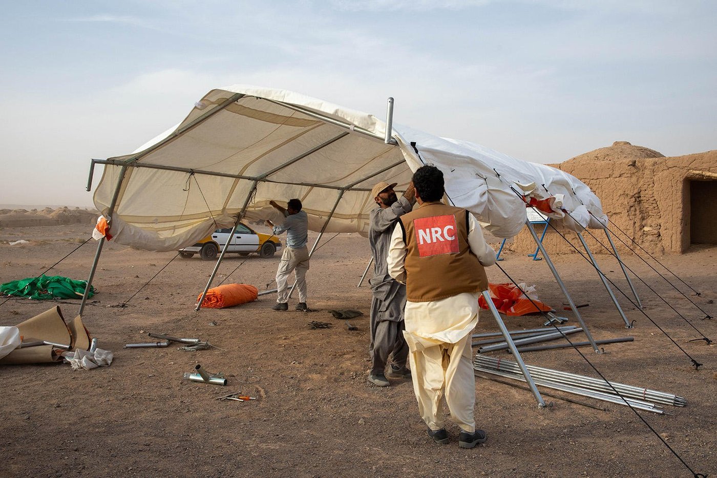 NRC staff setting up a large white tent.