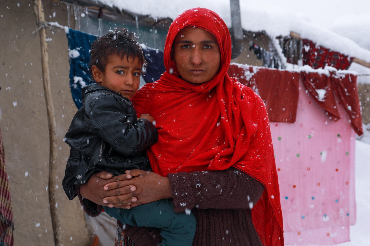 Shahnaz makeshift home collapsed under the weight of heavy snow in an informal settlement in eastern Kabul this week. The family is now forced to live with neighbors as the temperature drops up to -20C during the night.
Shahnaz, 34, a widow was sleeping with her three children when the roof of their substandard makeshift home fill in onto them and now, she stays with three other families in shared two-room house in the camp.
“We were in deep sleep when the beam broke and the roof collapsed over us. I grabbed my children to protect and start shouting then the neighbors rushed to help us,” Shahnaz said. Several makeshift homes have reportedly collapsed during the last snow fall and many families are either staying with neighbors or with relatives. NRC with support from donors, German Development Bank (KFW) and Danish International Development Agency (DANIDA) improved and upgraded 330 shelters and built another 154 permanent homes across the capital, Kabul. Our team have observed that many of these upgraded homes are hosting more than one family.
Shahnaz and her three children are now staying with one of the neighbors. “Thanks God, we are not alone here and if the government is not being able to support us, the people do care about each other with their little in hand,” she says.
The mother says she begs on the streets to protect her children. “The two biggest challenges we were facing was food and the cold and now, shelter is also included on the list,” she added. Photo: Enayatullah Azad / NRC
