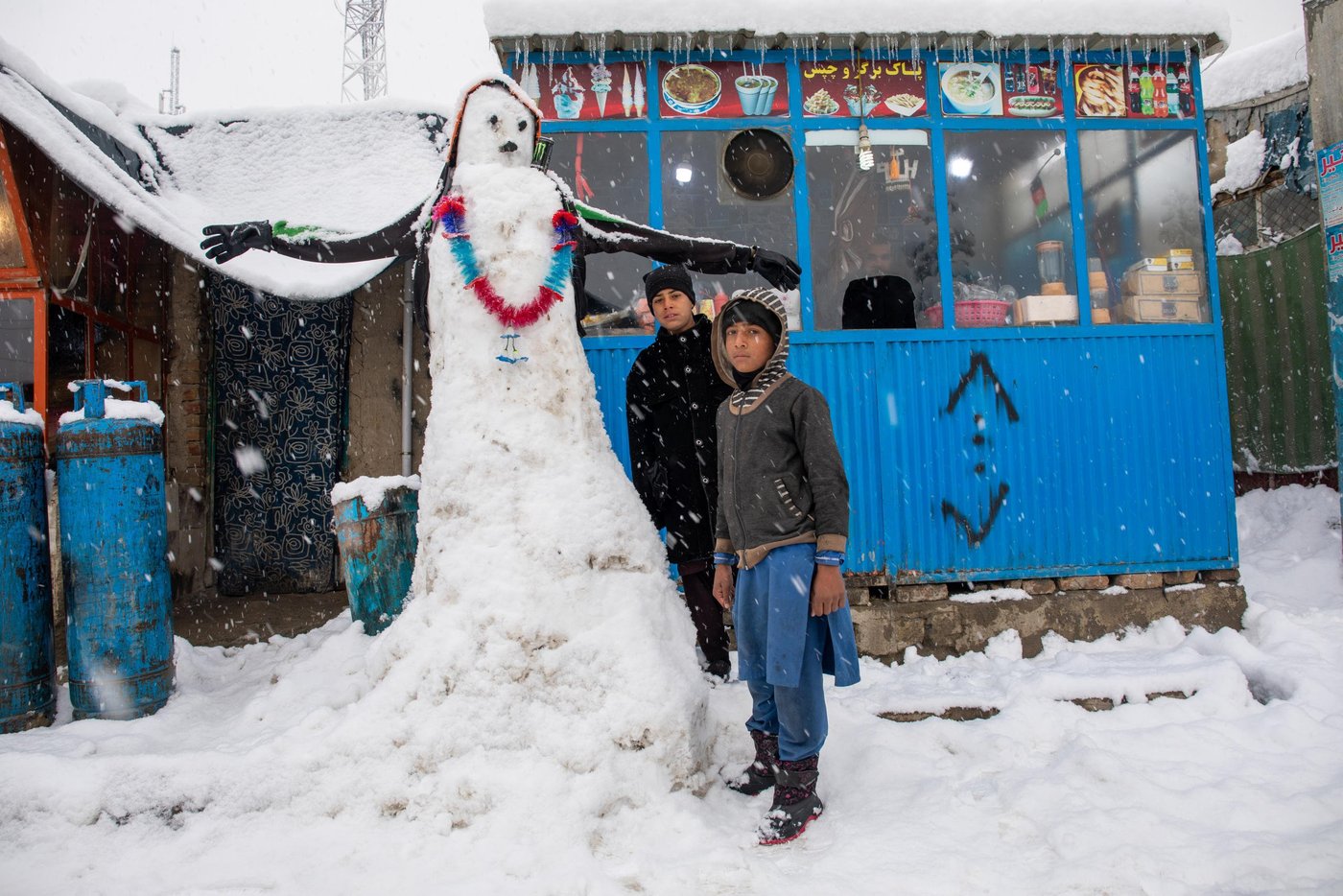 NRC shelter and WASH team doing a walkabout in Hiwadwal IDP Settlement in Kabul on a snowfall day. It’s first winter snow in Kabul and thousands of IDP families are living in substandard makeshift making them disposed to freezing temperature. Photo: Enayatullah Azad / NRC