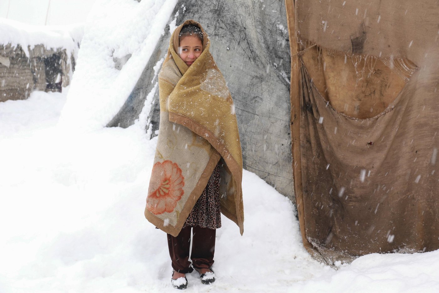 “It was very cold inside and I thought if I go outside and walk I might feel warmer,” says Roqia, 11, standing outside her makeshift home in a snowy day in KABUL.
Rogia doesn’t have enough clothes and proper slippers to keep her warm in a cold. Her family do not have sufficient firewood to keep the oven burning all the time and they only burn it once in a day and if the weather is freezing cold, they might burn it twice in a day. They burn plastics, cartons, packets and other waste materials they have collected during the summer season.
“The house we have is out of plastic bags, blankets and mud. As soon as the oven dies the home gets cold,” she says. “It’s very cold during the night and we wakeup many times due to cold. Sometimes, I feel pain and burn in my feet, legs and back due to the cold.”
Kabul gets very cold during the winter and last night only, the temperature dropped to -16 Celsius. Photo: Enayatullah Azad/ NRC