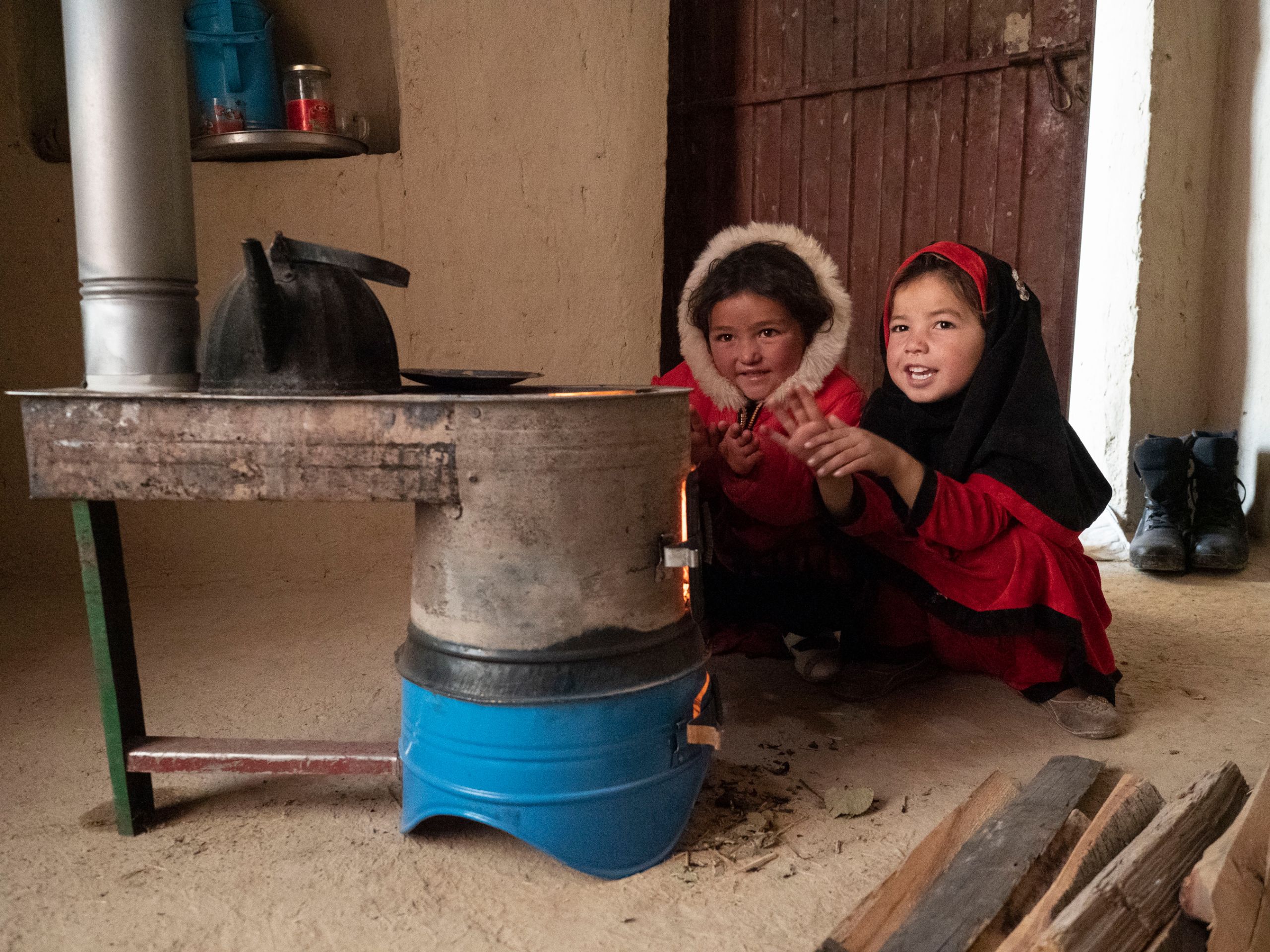 Die Schwestern Salima, 6, und Samira, 5, können sich endlich an dem Ofen wärmen, auf den sie so lange gewartet haben.